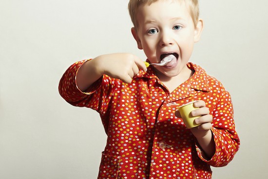 Bambino mangia uno yogurt